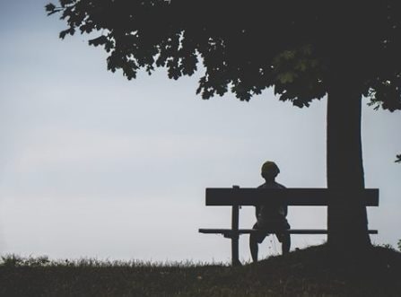 Picture of person sitting on a bench contemplating